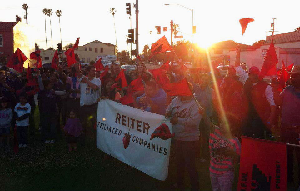 Comprehensive Immigration Reform rally in Oxnard, California on May 1, 2013, International Workers Day. Children and adults wave red and black UFW flags while holding a Reiter Affiliated Companies banner next to a company representative holding a UFW flag.